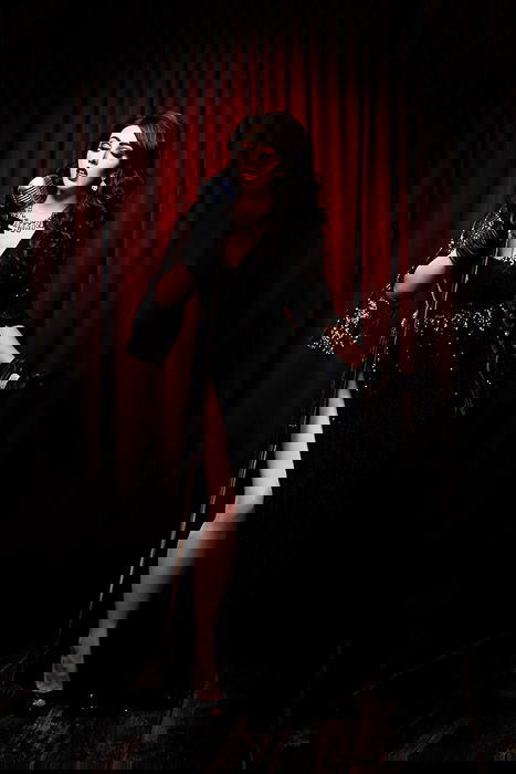 Atmospheric boudoir self portrait of a female model posing in a Gothic style cabaret stage